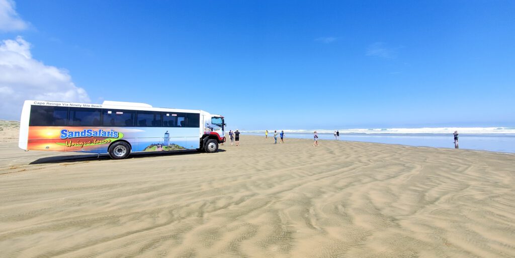 Tour bus on 90-mile beach by the te paki sand dunes northland new zealand